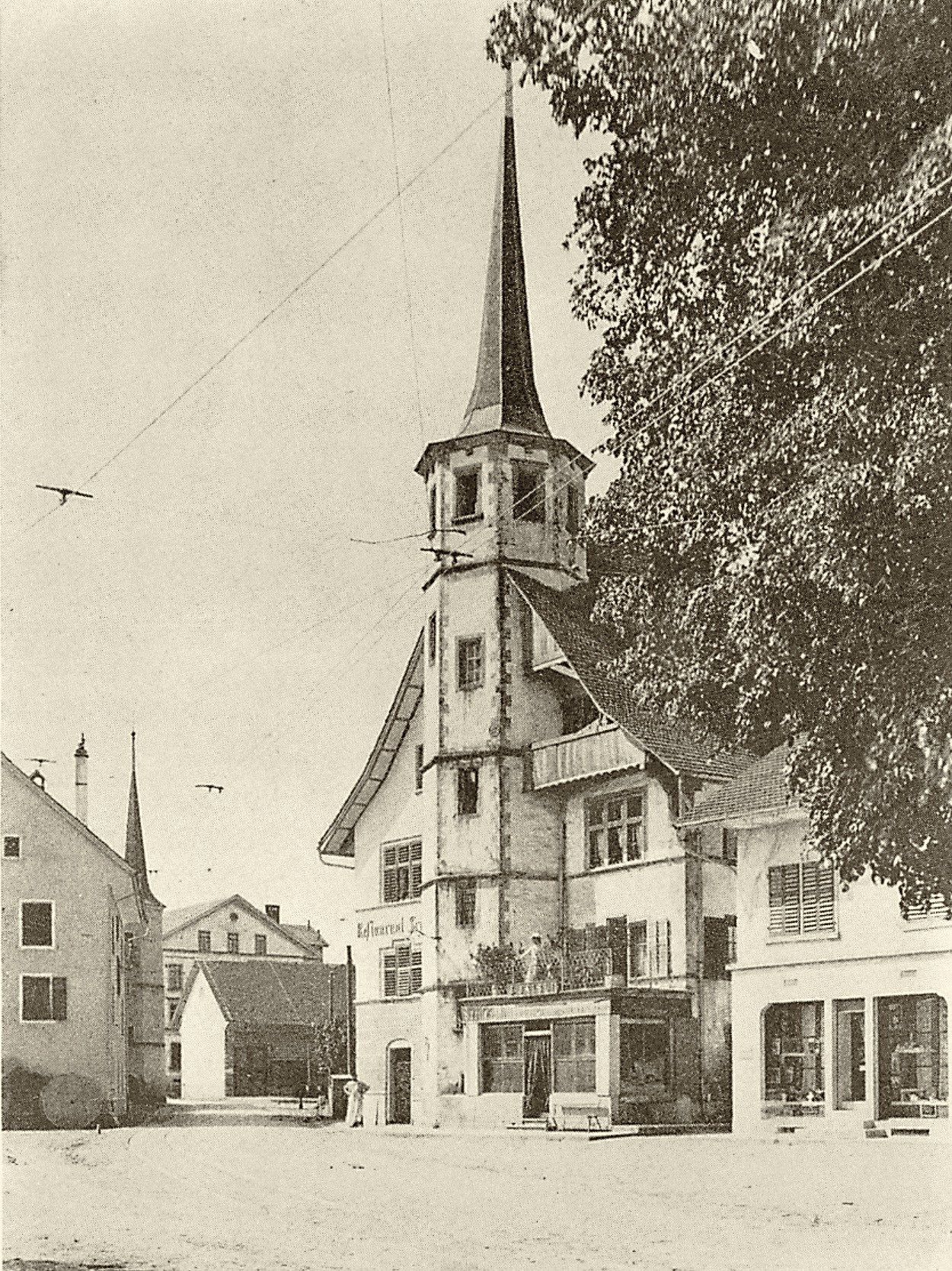 Historisches Foto des Hotel & Restaurant zum Schneggen mit umliegenden Häusern und Strasse aus dem frühen 19. Jahrhundert. Sepia-Foto zeigt die damalige Umgebung.