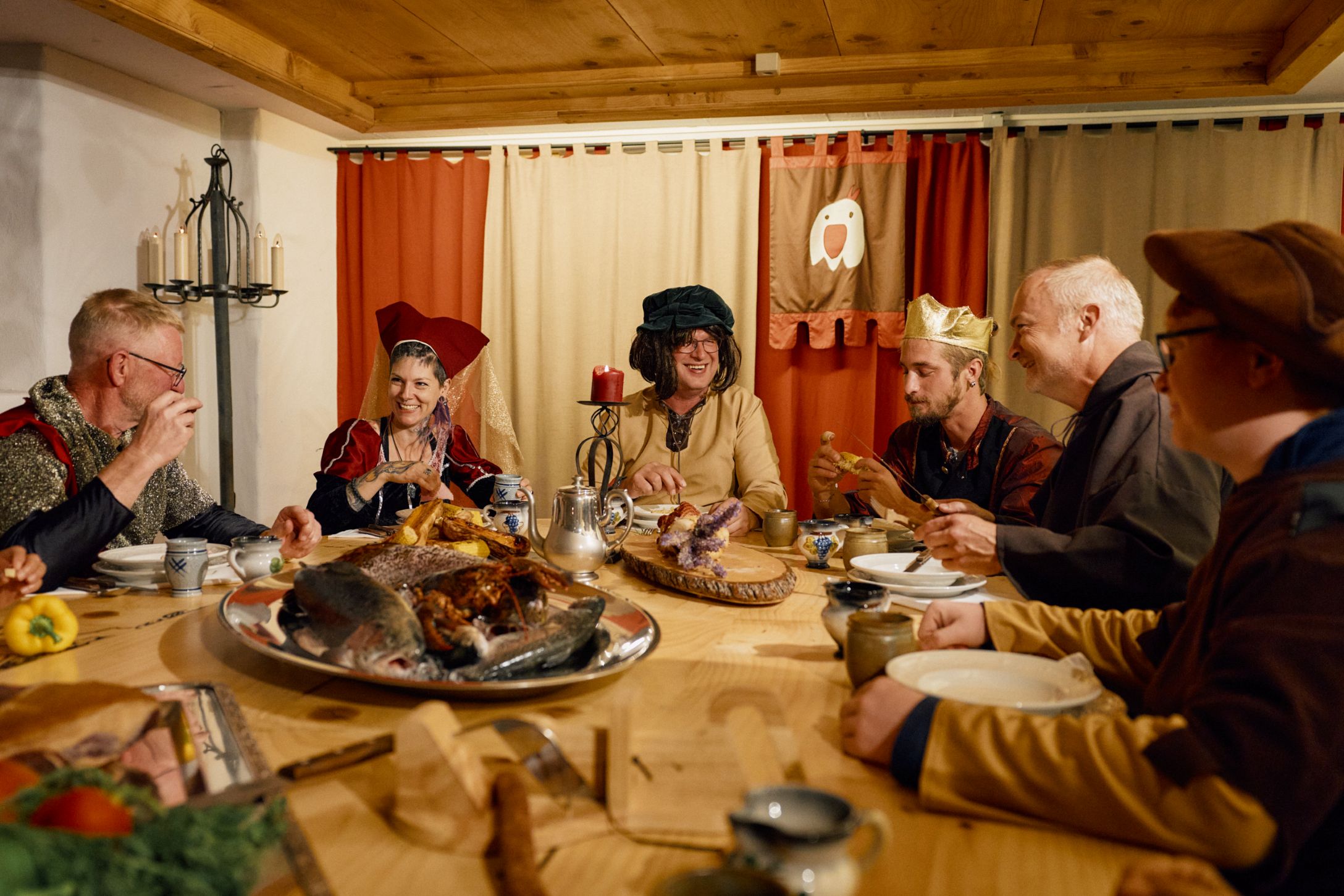 Rittertafel: Gäste geniessen ihre Tafelrunde bei Speis und Trank.
